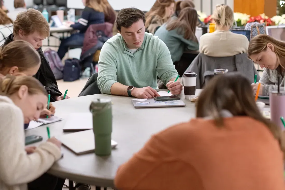 Students sitting at a table at a writing workshop.